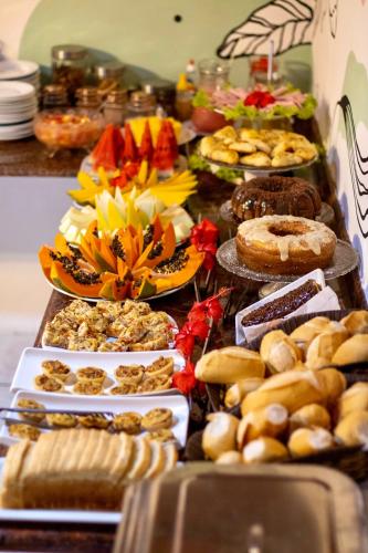 a table full of different types of food on plates at Pousada Pura vida in Itacaré