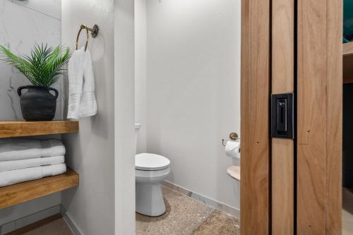 a bathroom with a toilet and a plant in it at Sommer House Inn-Aloha Room in Jasper