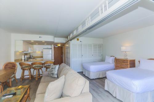 a bedroom with a couch and a bed and a kitchen at Ilikai Tower 1403 in Honolulu