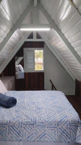 a bedroom with a bed in the attic at Toca do Caranguejo-Iate Clube Rio Verde - Ilha Comprida in Cananéia