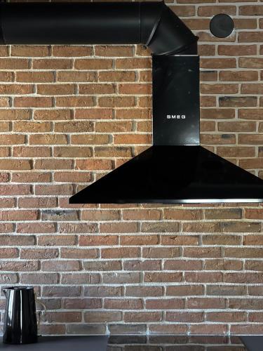 a black extractor hood above a brick wall at hellofrom Tobacco Warehouse in Kavála