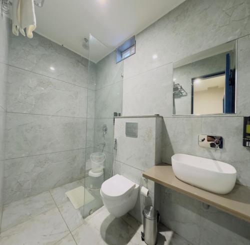 a bathroom with a toilet and a sink and a shower at Hotel The Sun B&B in New Delhi