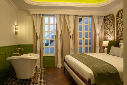 a bedroom with a tub and a bed and a window at Roma Nueve Dos Hotel Boutique in Mexico City