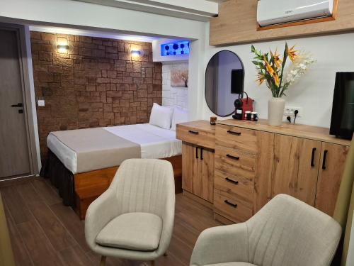 a bedroom with a bed and two chairs and a mirror at Luxury Private Suite in Rhodes Town