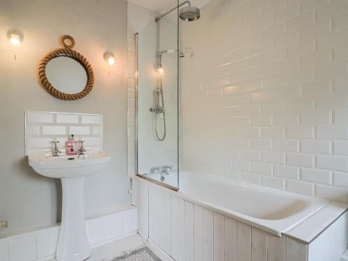 a bathroom with a tub and a sink and a shower at The Nest in Lyme Regis