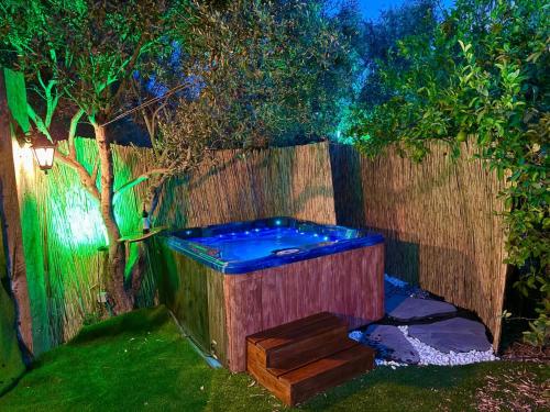 a hot tub in a backyard with a fence at בוסתן החורש in Haifa