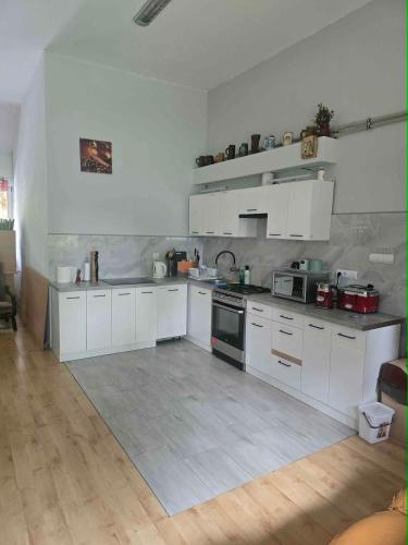 a large white kitchen with white cabinets and appliances at Pokoje gościnne „SEN” in Iława