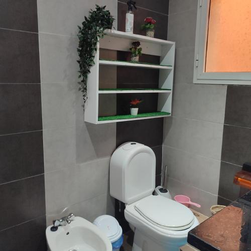a bathroom with a white toilet and a sink at lux appartement avec piscine in El Jadida