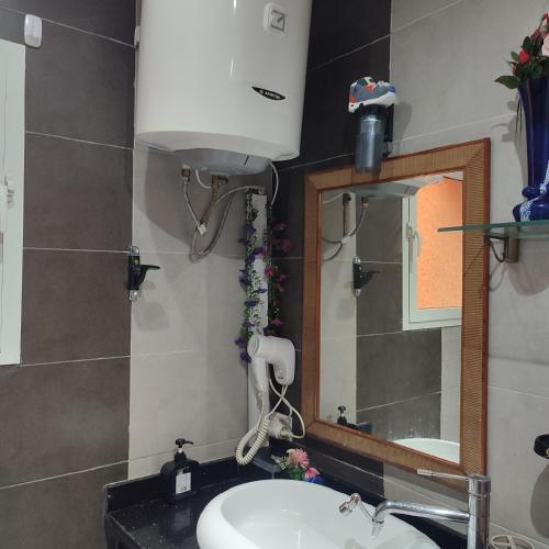 a bathroom with a sink and a mirror at lux appartement avec piscine in El Jadida