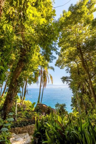 a view of the ocean through the trees at Pousada Lagamar in Praia Vermelha