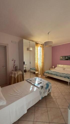 a large room with two beds and a table at Mirage B&B in Alezio