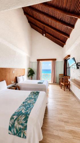 a hotel room with two beds and a view of the ocean at “Magic Sunrise at Cancun” in Cancún