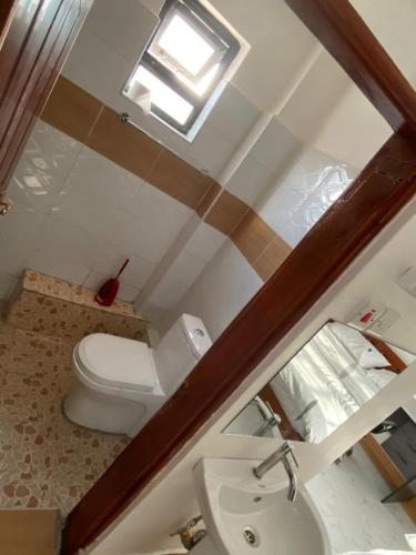 a bathroom with a toilet and a sink at Shawn's Hub in Ruaka