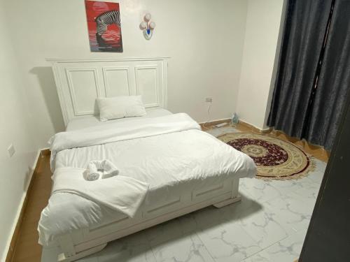a bedroom with two beds with white sheets at Shawn's Hub in Ruaka