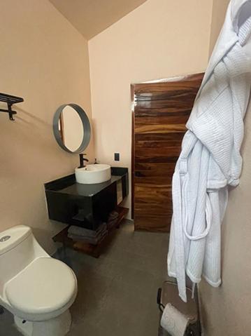 a bathroom with a toilet and a sink and a mirror at Soulchitlán in Suchitlán