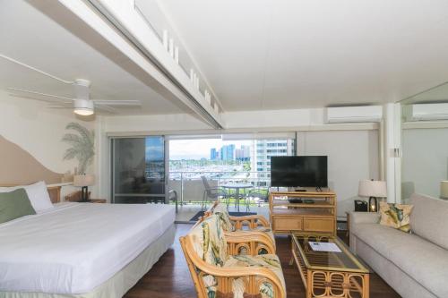 a bedroom with a bed and a couch and a tv at Ilikai Tower 633 in Honolulu