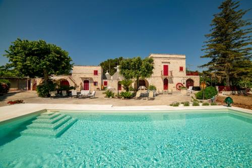 a large swimming pool in front of a house at Masseria Trulli Bruni in Locorotondo