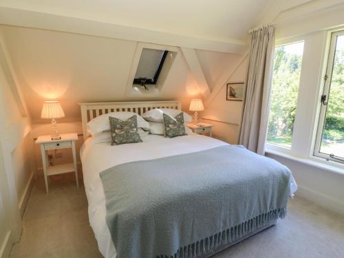 a bedroom with a bed with two lamps and a window at The Barn at Frog Pond Farm in Salisbury