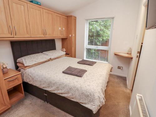 una camera da letto con un grande letto e una finestra di Willows Lodge a Windermere