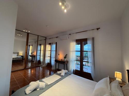 a bedroom with a large white bed and a bathroom at Athos Sea Villa in Ouranoupoli