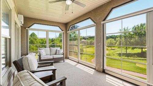 a screened in porch with chairs and windows at TeeTime Green On the Fairway in Camdenton