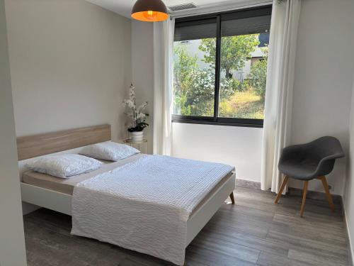 a bedroom with a bed and a chair and a window at Villa luxueuse et Moderne avec piscine ! in Béziers