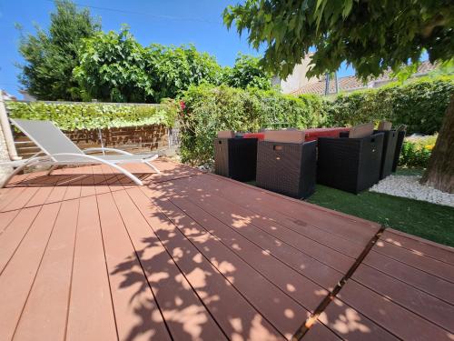 a deck with a white chair and furniture on it at Le Ciel Bleu in Arles