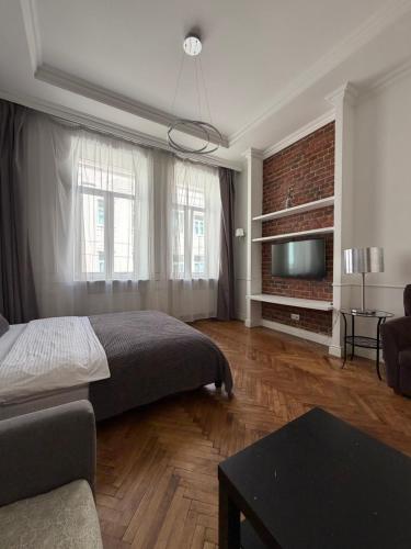 a bedroom with a bed and a couch and a tv at Historical space in Lviv