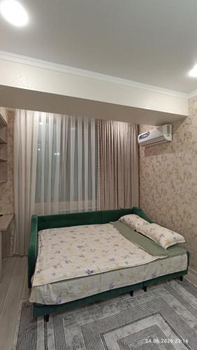 a bedroom with a green bed in a room at Osh apartment in Osh