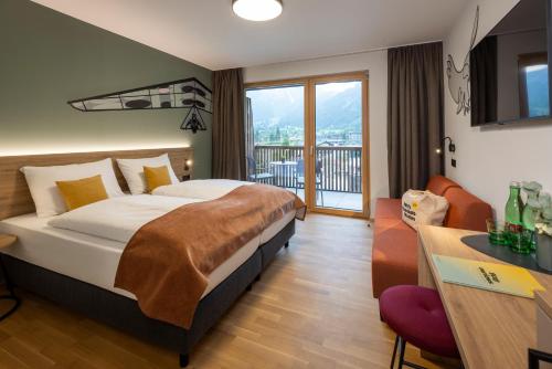 a hotel room with a bed and a balcony at JUFA Hotel Werfenweng in Werfenweng