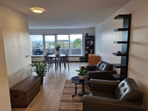 a living room with a couch and chairs and a table at Top floor apartment with view in Reykjavík
