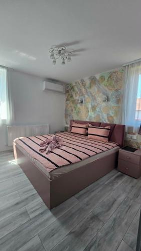 a bedroom with a large bed with a painting on the wall at Casa MADE in Turda