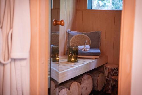 a room with a bench with candles and a mirror at AuxiliumWellness Get Back to Serenity in Grobbendonk