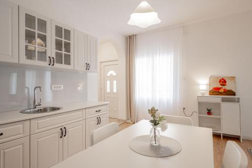 a kitchen with white cabinets and a table and chairs at Harmony Point in Bar