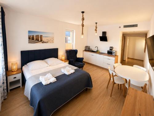 a bedroom with a bed and a table and a dining room at AMD Apartamenty Ustka *** in Ustka