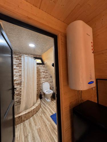 a small bathroom with a toilet in a room at Garden Cottages in Mestia