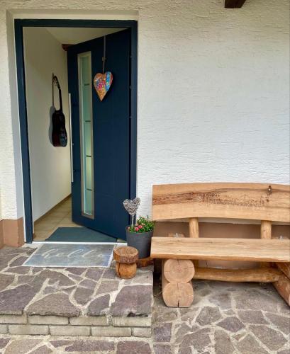 a wooden bench sitting in front of a door at Haus am Bach in Erl