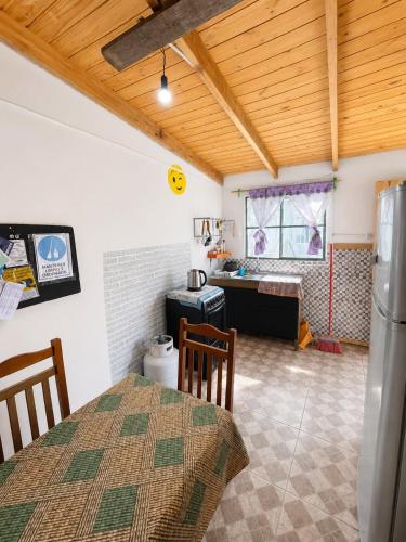 a kitchen and dining room with a table and a refrigerator at Alojamiento EYO en Chuy con Baño Privado y Aire Acondicionado in Chuy