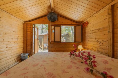a bedroom with a bed in a log cabin at Camping Villaggio Egad in Favignana