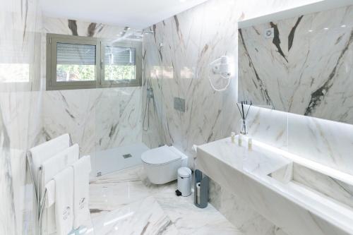 a white bathroom with a sink and a toilet at Quinta da Terrincha in Torre de Moncorvo