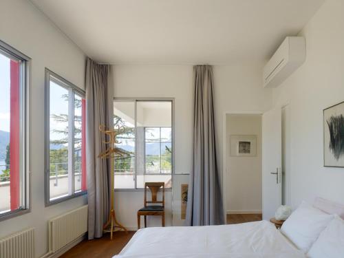 a bedroom with a bed and large windows at Casa Navegna in Minusio