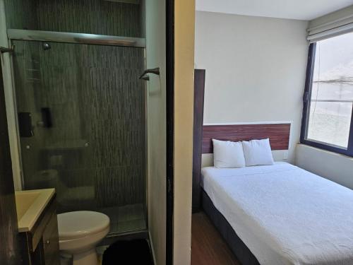 a small bathroom with a bed and a shower at Singular Sócrates in Mexico City