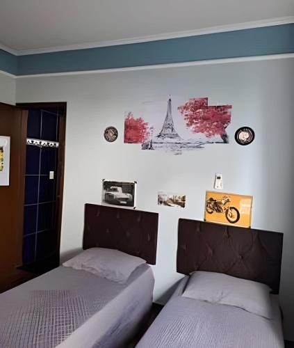 two beds sitting next to each other in a bedroom at Tecnohouse próxima ao Sesc in Franca