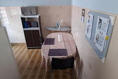 a small room with a table and a kitchen at Tecnohouse próxima ao Sesc in Franca
