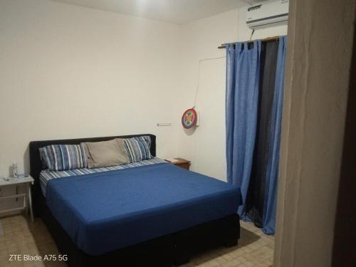 a small bedroom with a blue bed and blue curtains at L'Urbain in Ziguinchor