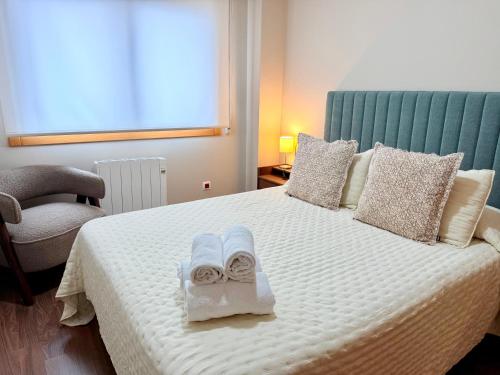 a bedroom with a bed with towels on it at Estudio en Villalonga in Pontevedra