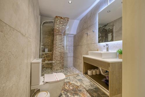 a bathroom with a shower and a toilet and a sink at Pietra Grand Suite in Nafplio