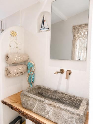 a bathroom with a stone sink and a mirror at Le Tiki Lodge in Fréjus