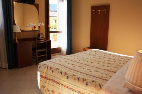 a bedroom with a bed and a desk and a mirror at Italia Risorta in Arsiero