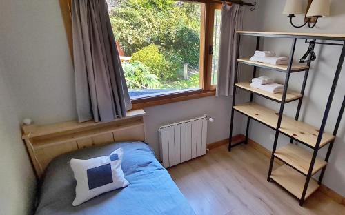 a bedroom with a bed and a window at Matices Patagonicos in San Carlos de Bariloche